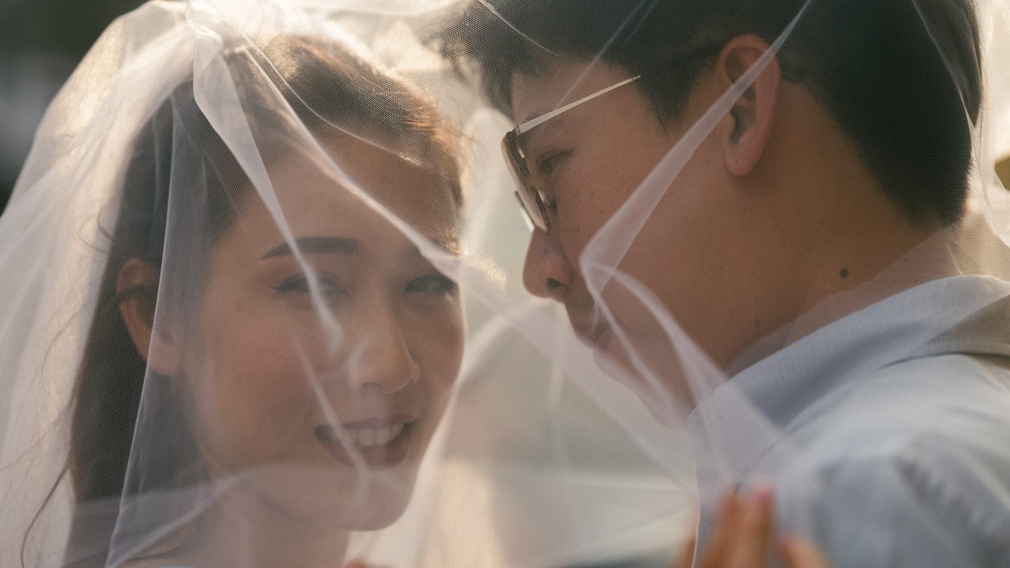 Both their faces under the veil, close together