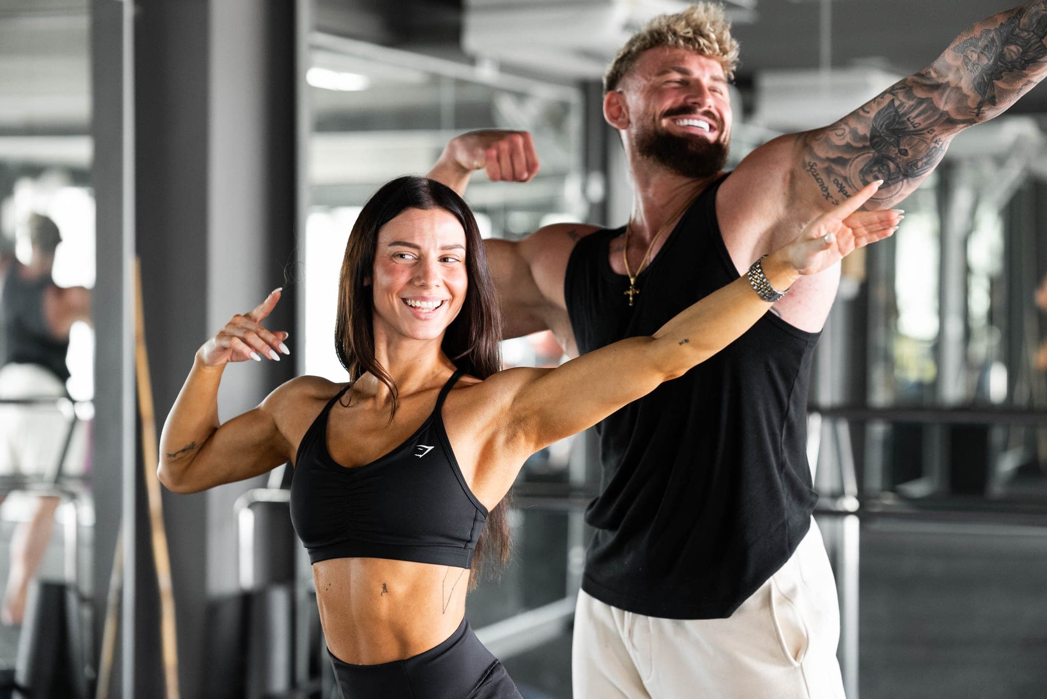 Both laughing, an arm flexed out wide