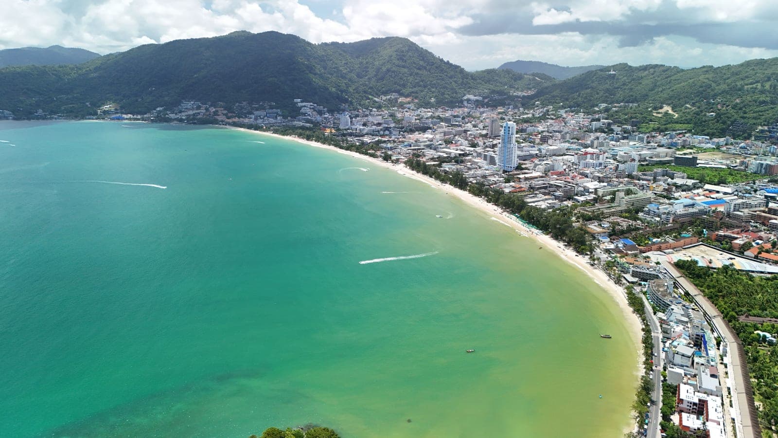 Patong's long curve of sand from the air, the town behind it and green hills beyond