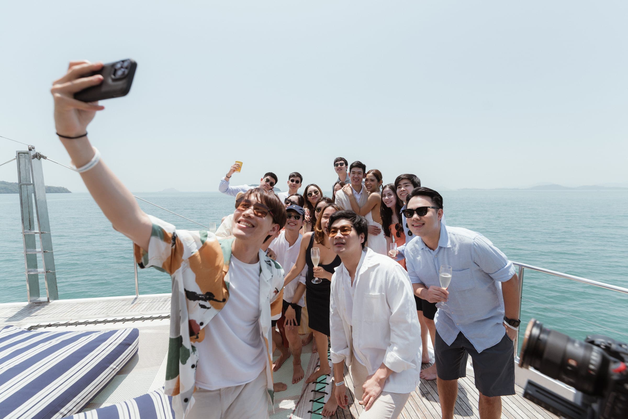 Group taking a selfie at the bow of a yacht, everyone squeezed into the frame