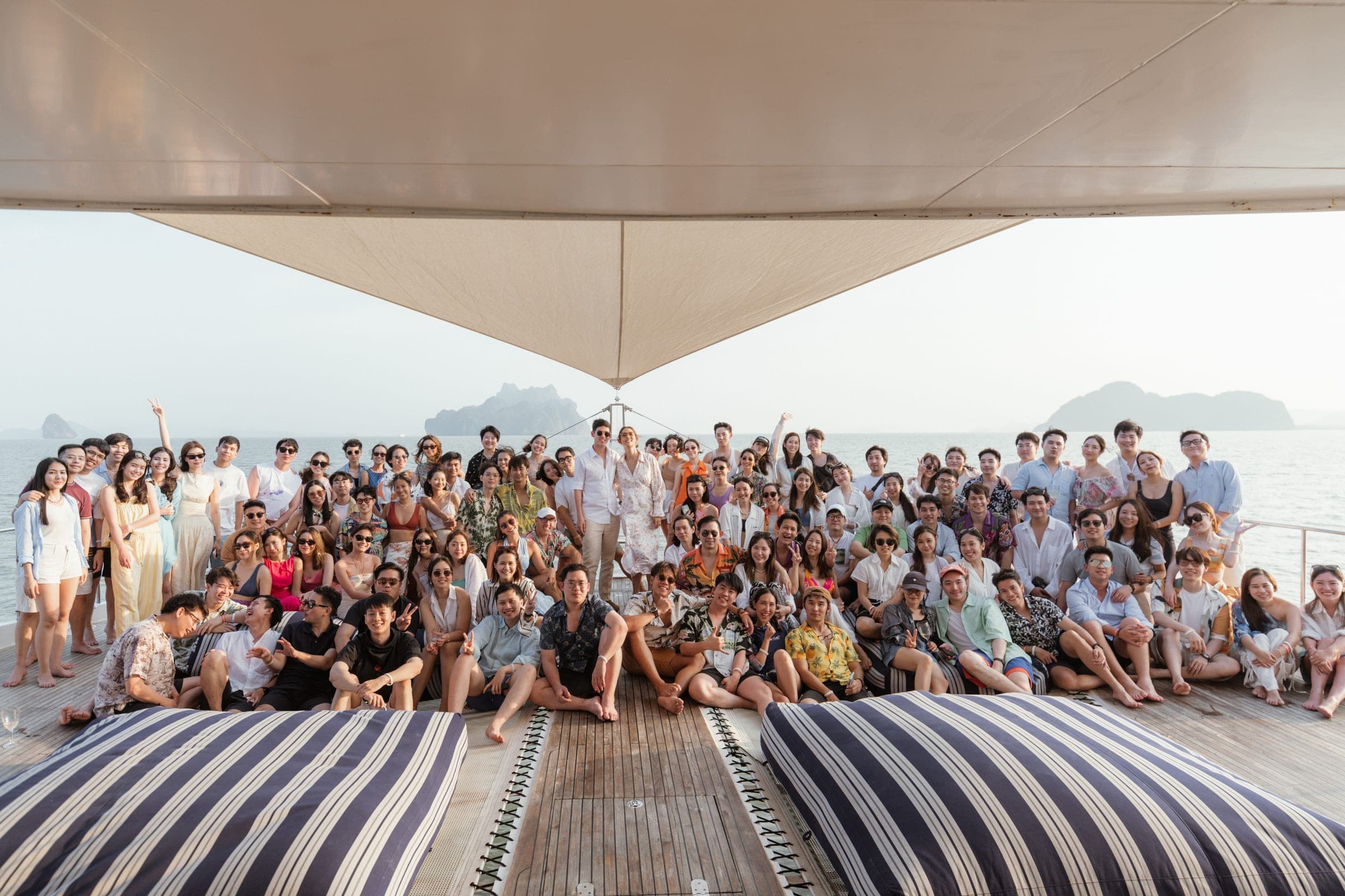A whole party of guests on the deck of a yacht under the shade sail